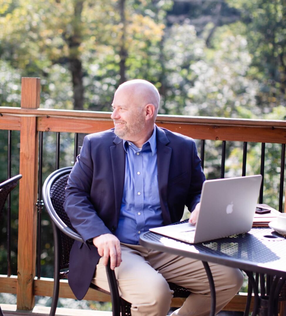 Jim working on a laptop outdoors on a sunny deck in Northern Chester County, PA