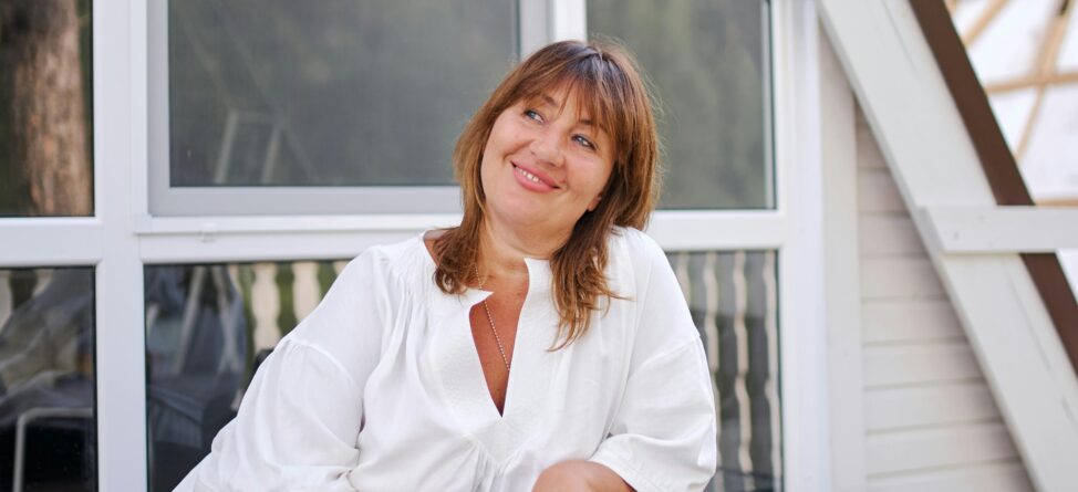 Woman smiling while sitting outside a modern home